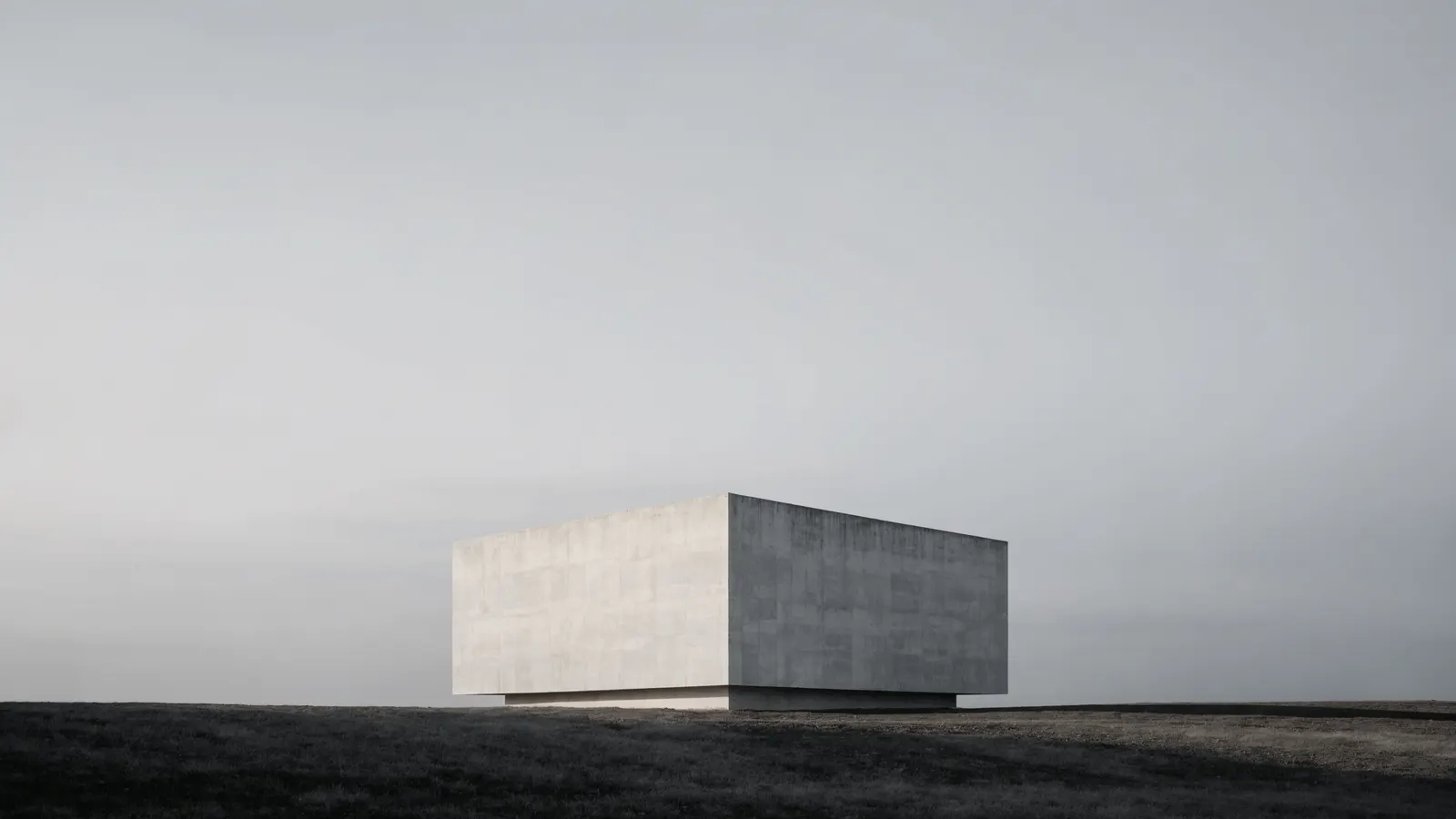 A single white volume standing in soft overcast light — the subject of an essay on building for permanence.