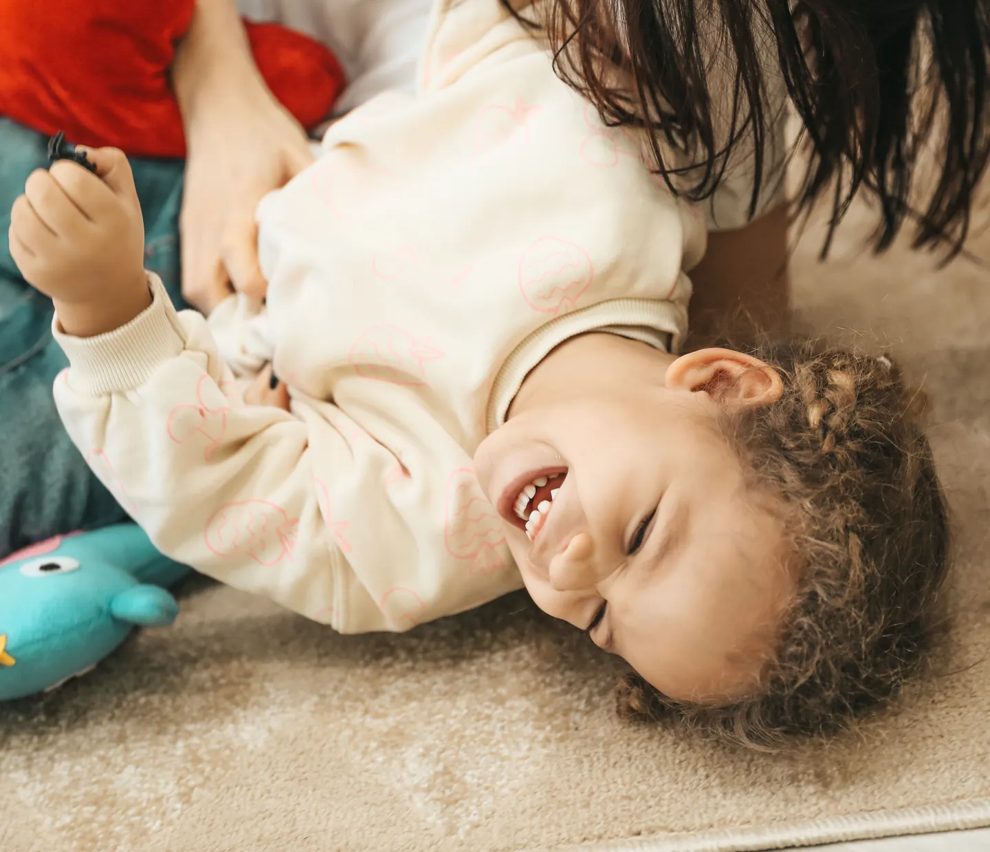 A child laughing in a daylight-filled room